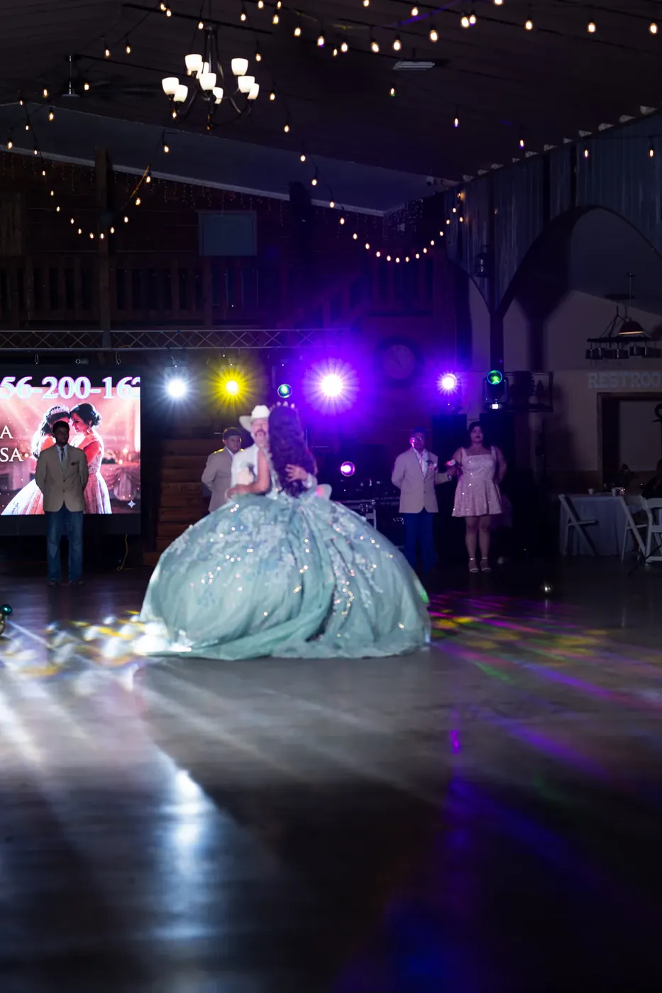 Quinceañera bailando su vals bajo luces de colores